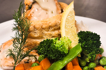 A plate of chicken pot pie and vegetables.