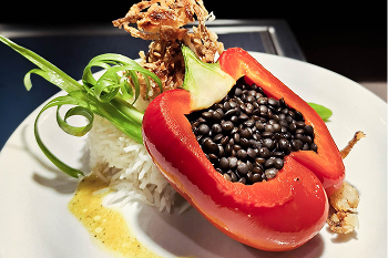A dish of rice and a stuffed bell pepper.